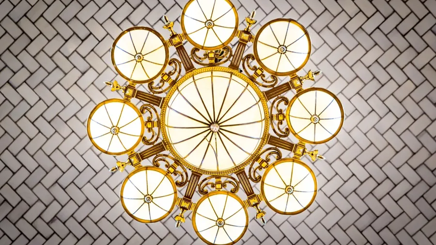 Elegant ceiling light fixture with a decorative design on a textured ceiling.