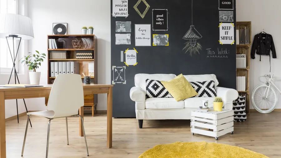 A cozy living room with a white sofa, wooden furniture, a bicycle, and a chalkboard wall with motivational quotes.