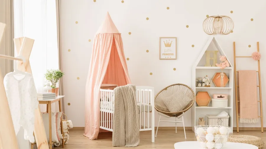 A brightly lit baby nursery setup in pink and beige tones