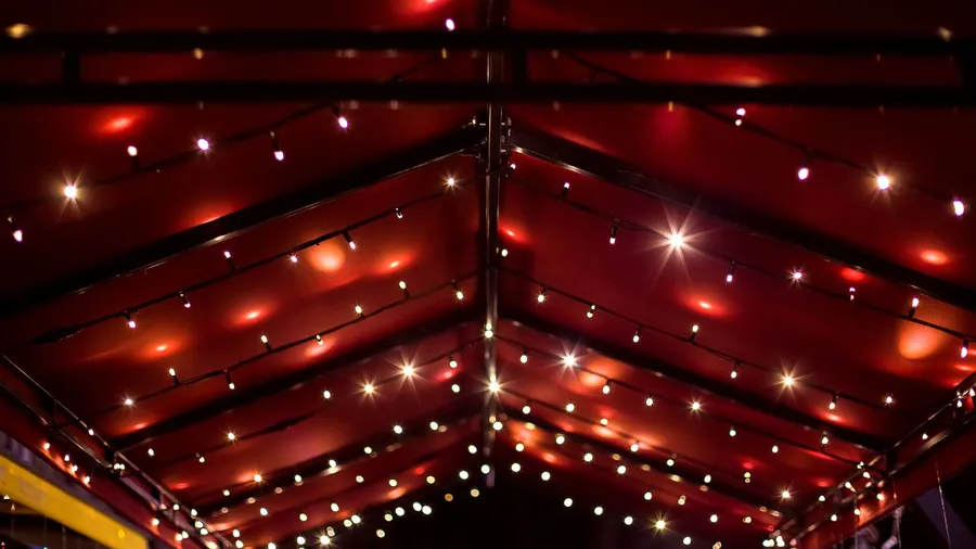 A red canopy with string light garlands.