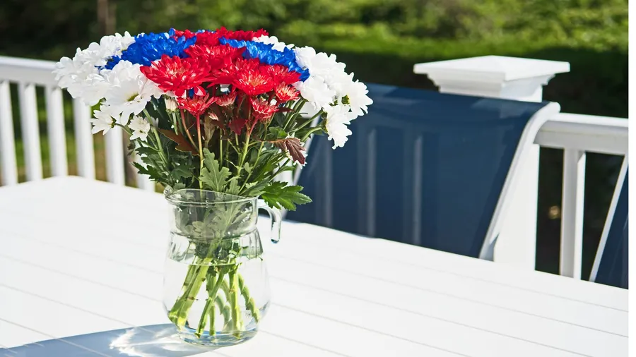 A beautiful floral Memorial day centerpiece with red, white, and blue flowers arranged in a vase.
