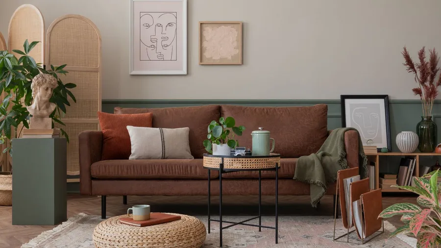 A cozy living space with a brown sofa, assorted cushions, a small coffee table, and artwork on the wall, creating a warm and inviting atmosphere.