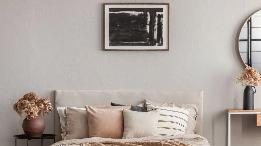An abstract monochrome art piece hanging on the wall above the bed.