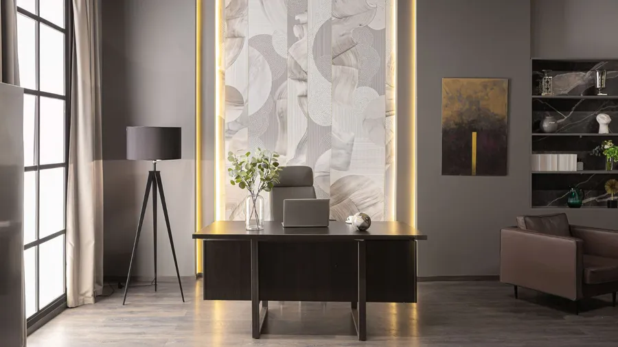A modern office space featuring a sleek desk, a stylish floor lamp, decorative wall art, and elegant lighting.