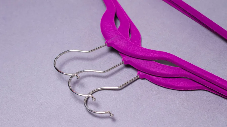 Purple velvet hangers on a gray surface.