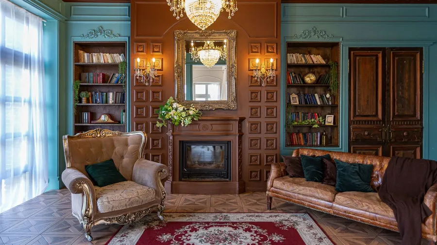 A cozy living room interior with leather sofa, armchair, rug, fireplace, and built-in wooden bookshelf with vintage deocr accents and books.