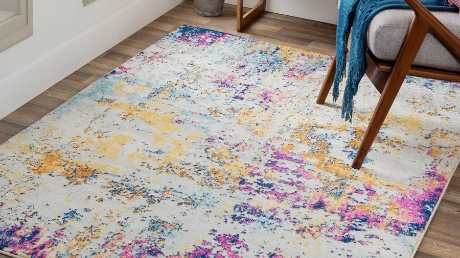 A colorful rug with a chair on a wooden floor.
