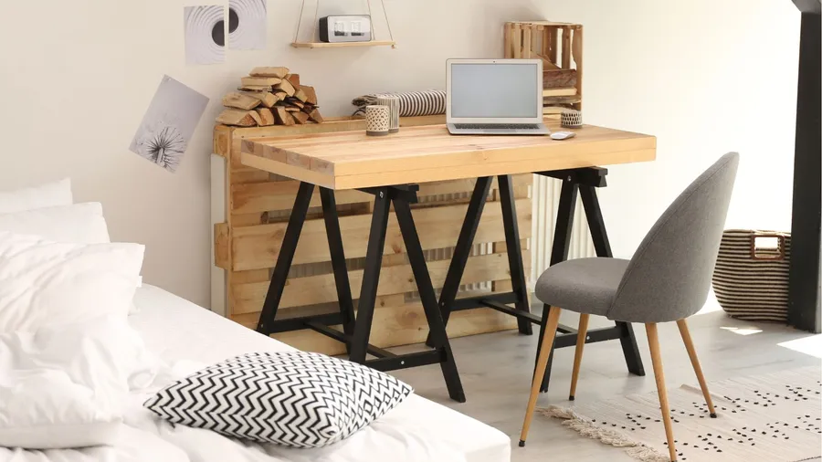 The workspace in the bedroom features a wooden desk paired with a gray chair. It's designed for both comfort and functionality.