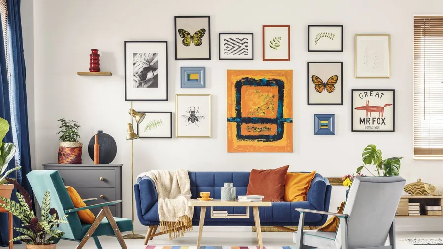 A living room interior with a cozy blue sofa, wooden coffee table, houseplants, armchairs, and a personalized art wall.