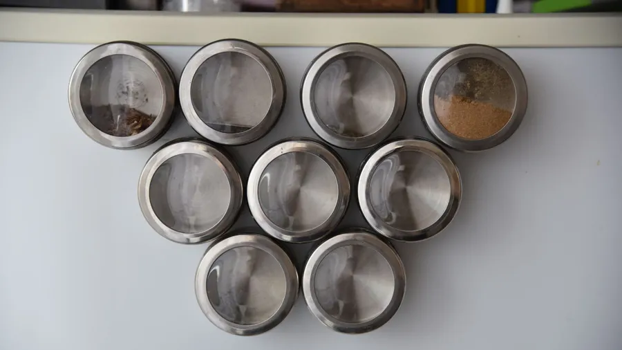 Magnetic spice containers attached on the fridge.