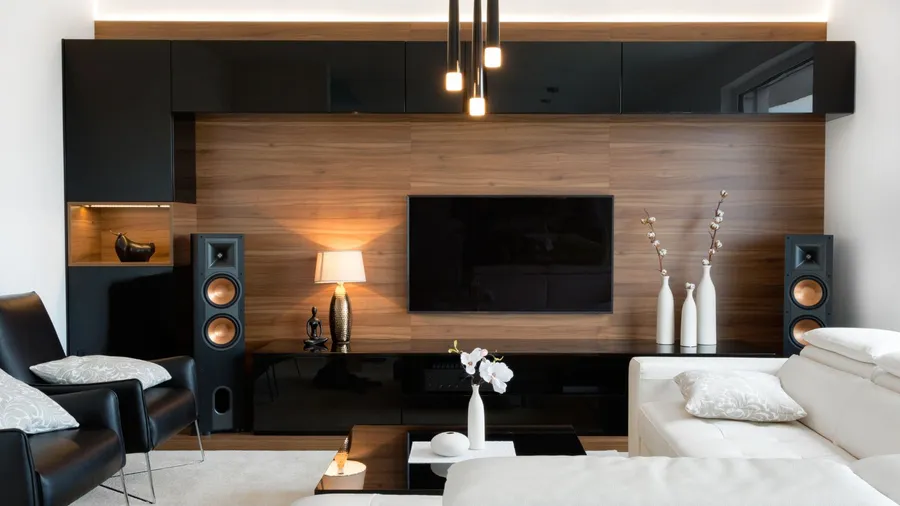 A stylish living room displays a sleek entertainment unit with decorative elements and a cozy seating arrangement.