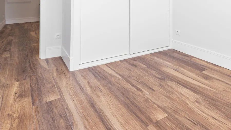 A room with wooden flooring and white walls.