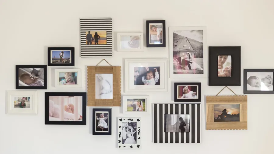 A personalized white wall with framed family photos.