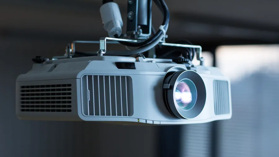 A modern laser projector hanging from the ceiling.