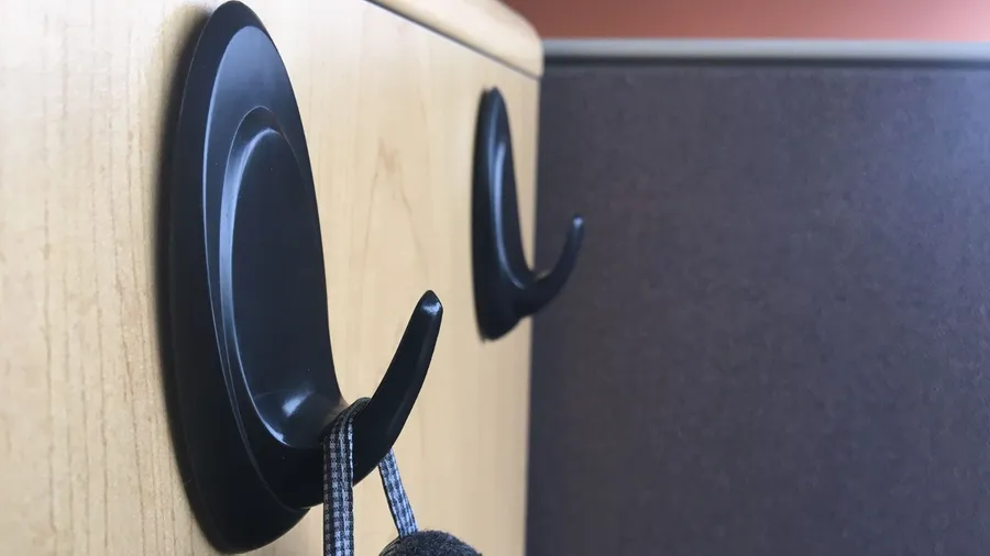 Black adhesive hooks on a cabinet.