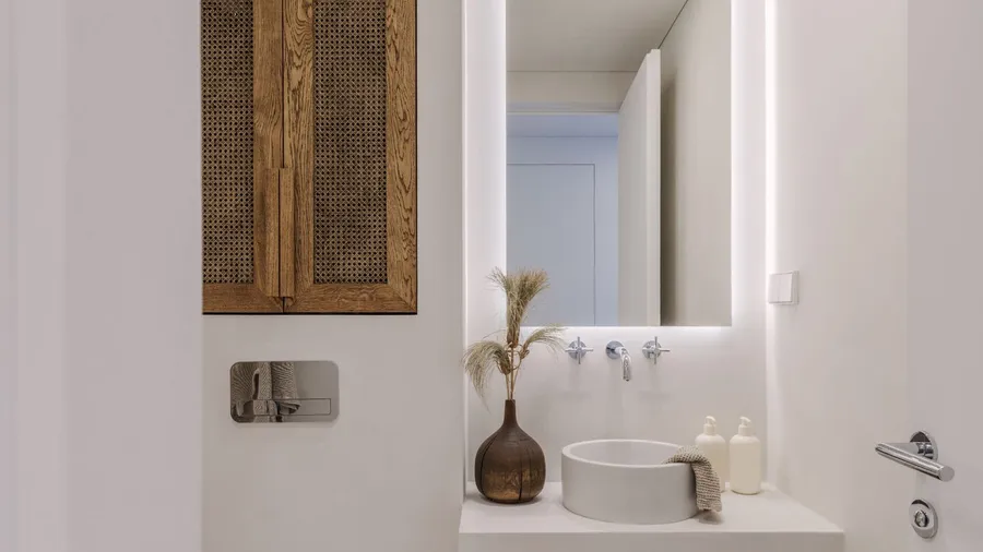 A minimalistic Japandi style bathroom in brown and off-white shade with vessel sink and wall-mounted tap.