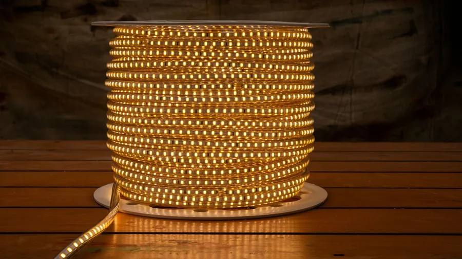 A roll of LED rope light on a wooden table.
