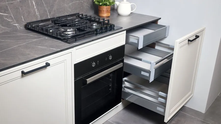 A kitchen interior with marble countertop and backsplash, oven, and white pull-out shelves.