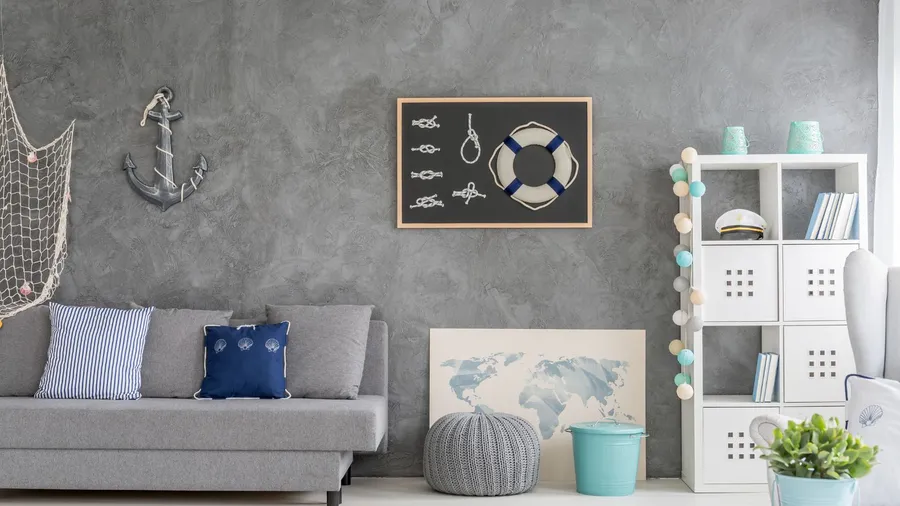 A living room with gray sofa, bookshelf, potted plant, and a poster on a Venetian plaster wall.