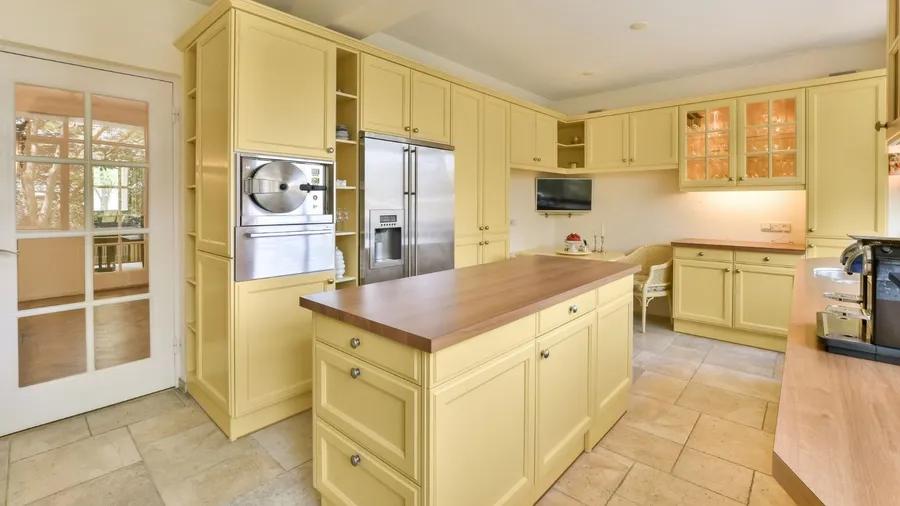 A cheerful yellow kitchen featuring bright cabinetry and a central island.