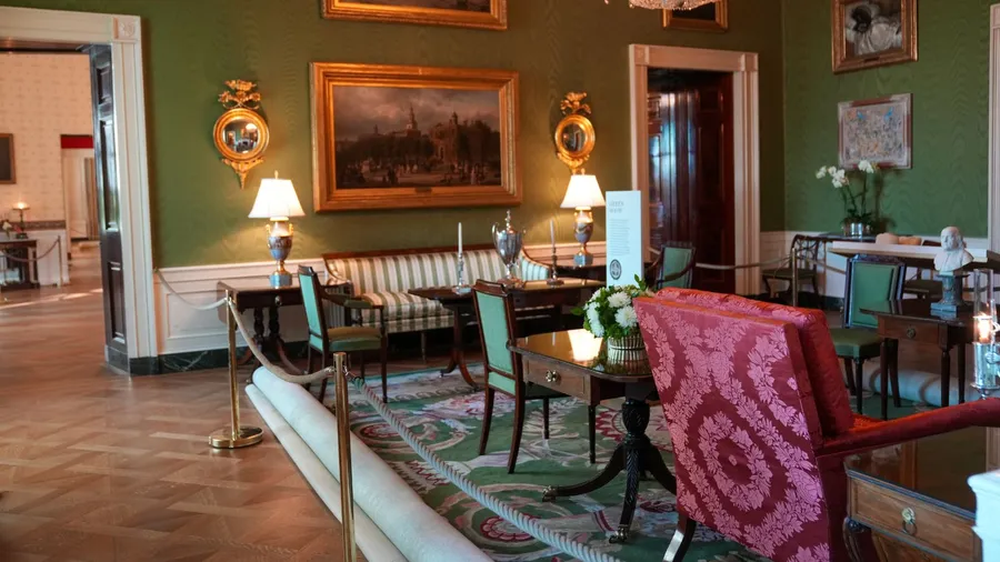 The Green Room of the White House, featuring Federal-style furniture including a sofa, chairs, and tables, with paintings and mirrors adorning the green walls