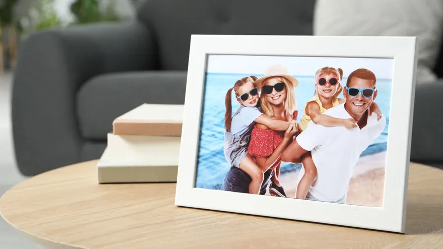 A framed family photo and books on a wooden coffee table.