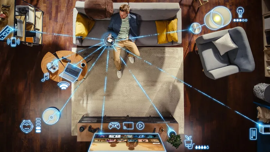 A person using a smartphone on a sofa and managing the appliances.