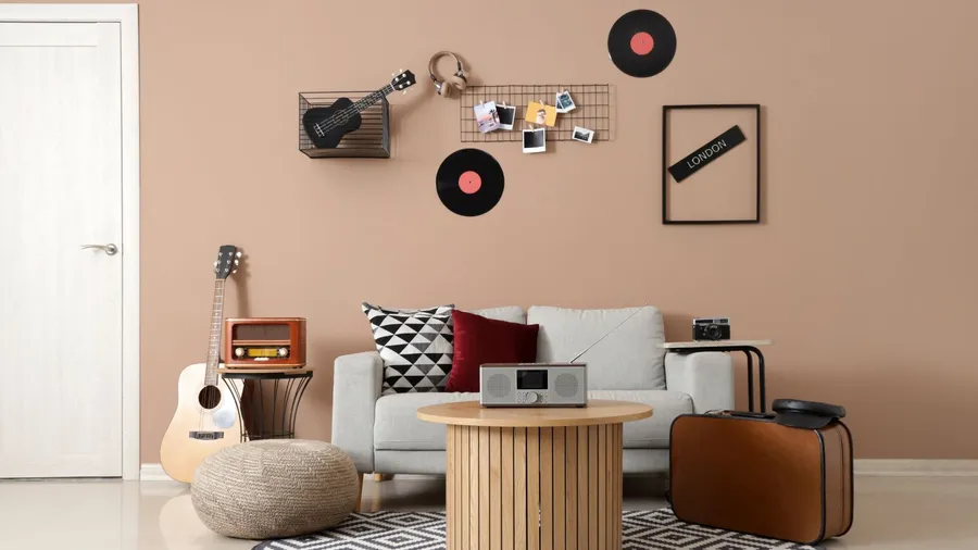 A room interior with sofa, guitar, coffee table, and a music wall.