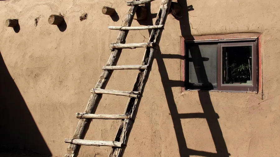 Southwestern ladder leaning against adobe wall in Taos Pueblo, New Mexico