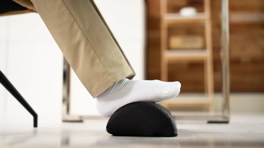 A man wearing beige pants and white socks with his feet on the footrest.