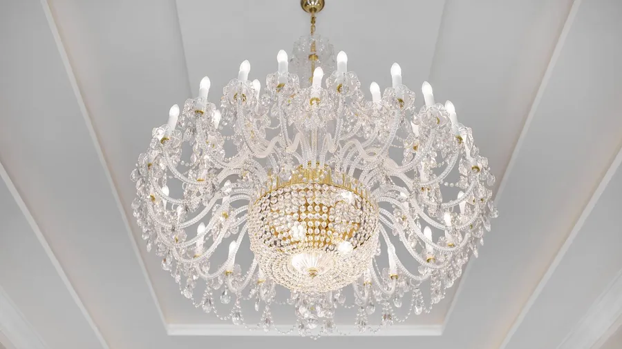 A beautiful crystal chandelier hanging from white tray ceiling.