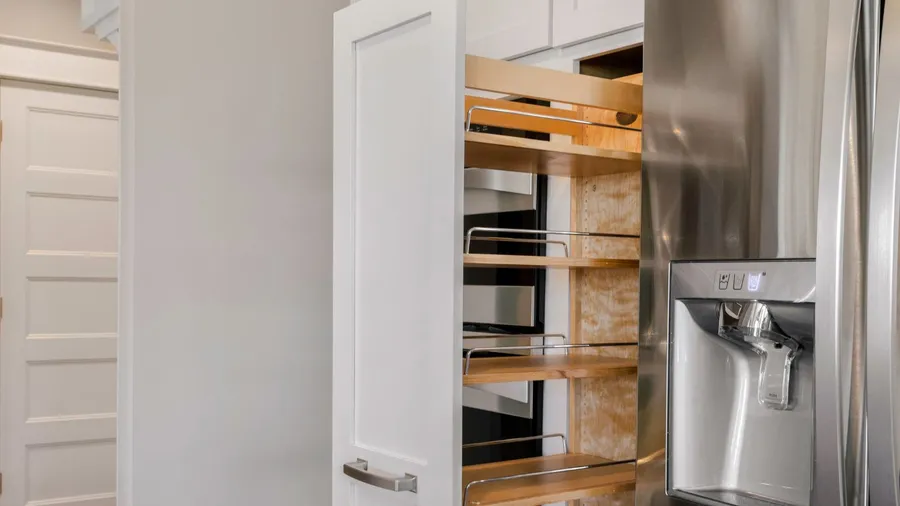 Modern kitchen with pull-out pantry on wheels.
