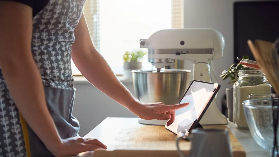 A woman using digital tablet in a kitchen.