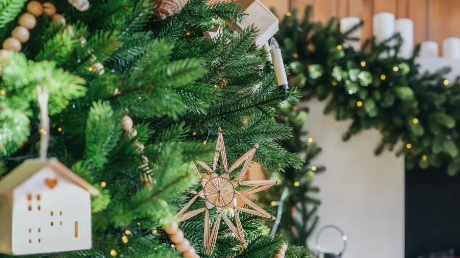 a beautifully decorated christmas tree adorned with wooden ornaments stands