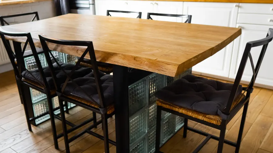 a big wooden dining table with glass blocks and metal