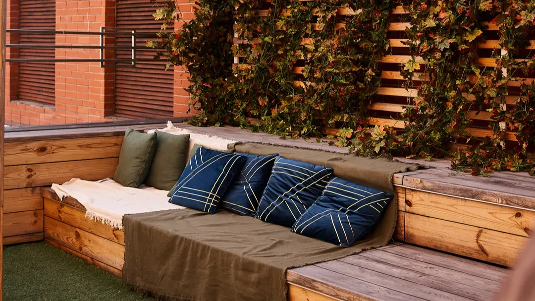 a cozy couch placed on a wooden deck surrounded by