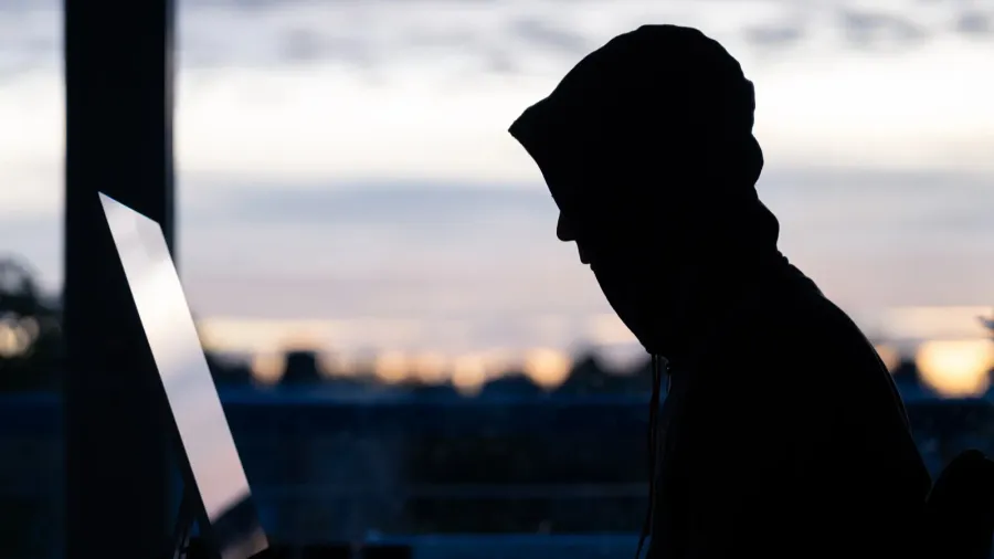 a hacker commiting digital crimes on a desktop computer
