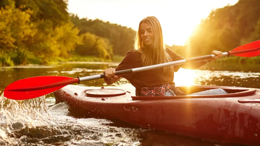 a joyful and smiling woman finds immense pleasure in kayaking