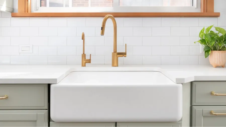 a kitchen sink detail shot with a gold faucet farmhouse