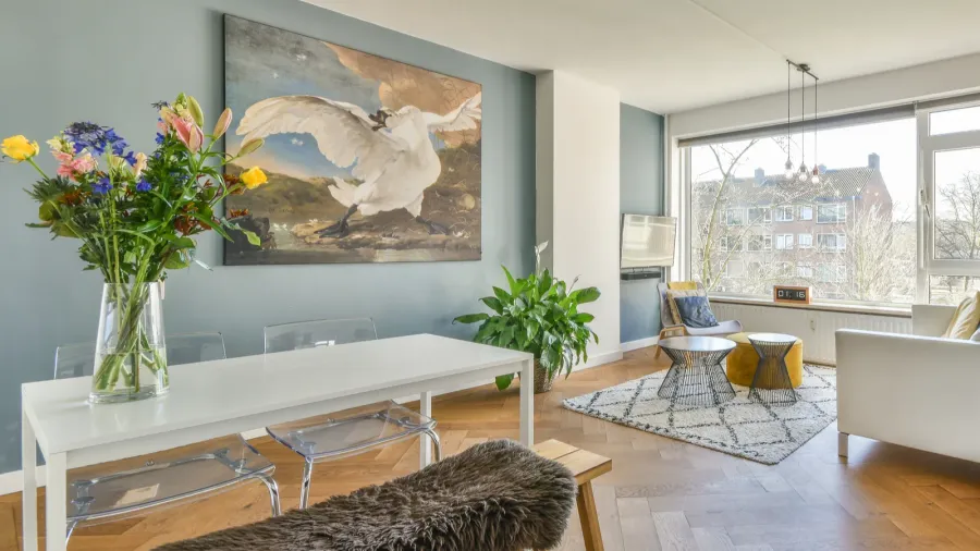 A modern living area featuring a striking artwork and floral arrangement.