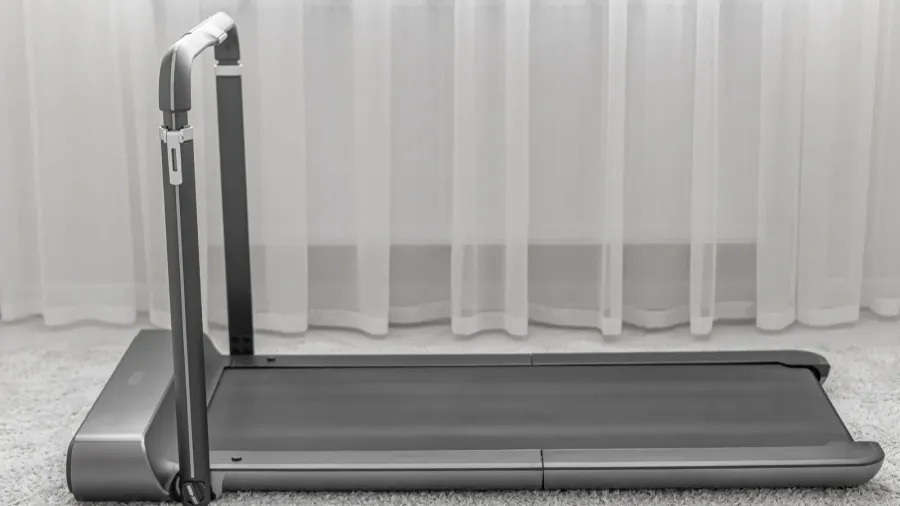 a modern compact treadmill with a foldable handlebar is placed