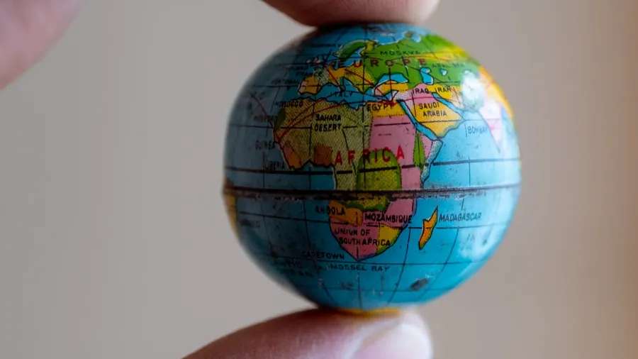 a person holding a small globe with a focus on