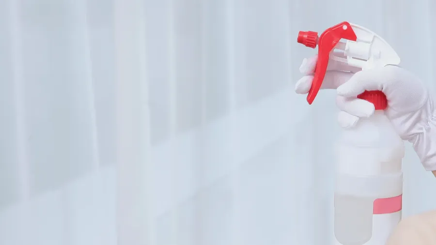 a plastic bottle of air freshener in the hands of