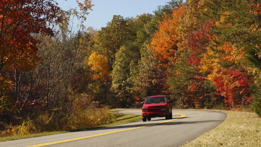 a red truck along a scenic autumn highway of great