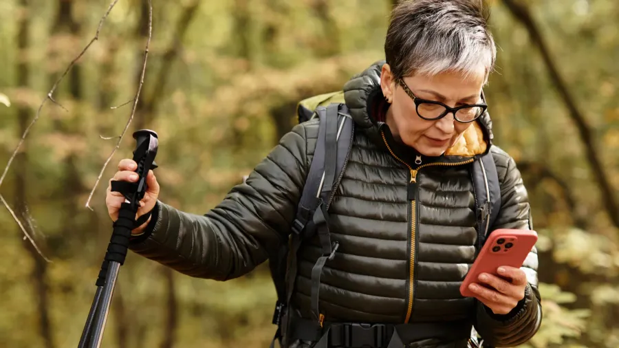 a senior woman with short gray hair hikes through a