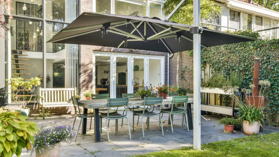 a spacious outdoor patio surrounded by lush greenery featuring a