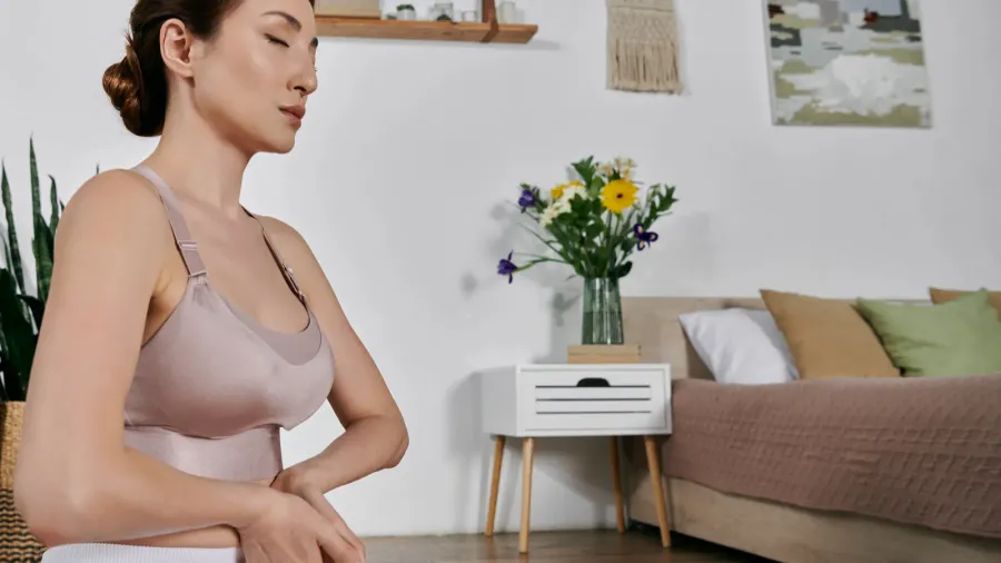 a woman in a crop top sits in a meditative