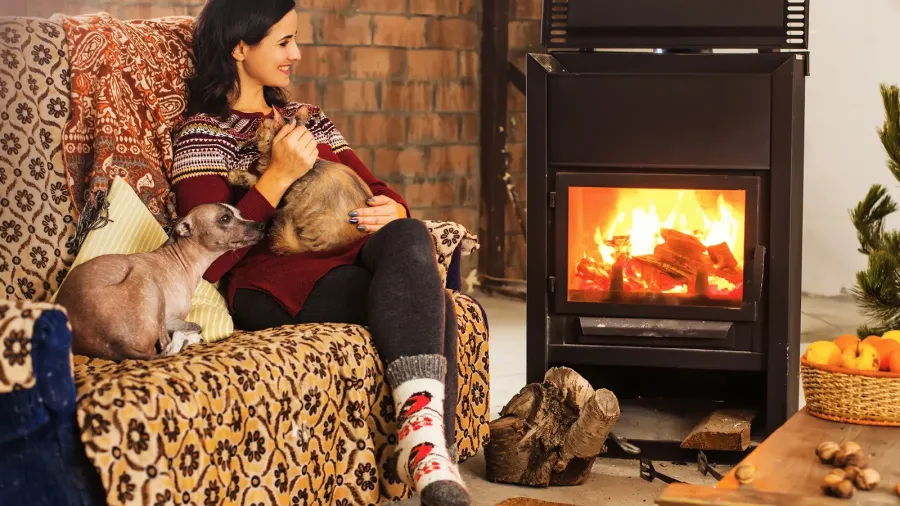 a young caucasian smiling woman sitting near a fireplace with