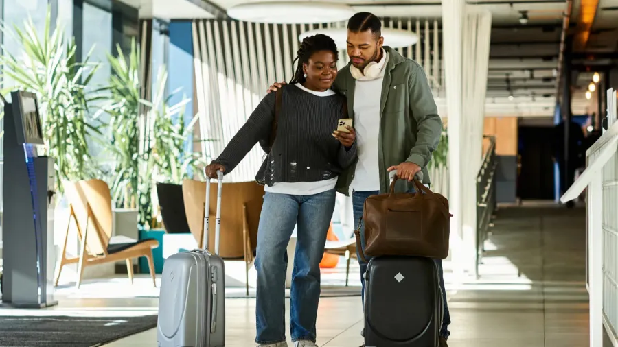 a young couple joyfully arrives at a modern hotel lobby