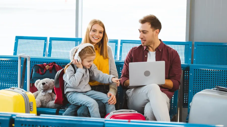 adorable daughter pointing with finger at laptop while sitting near